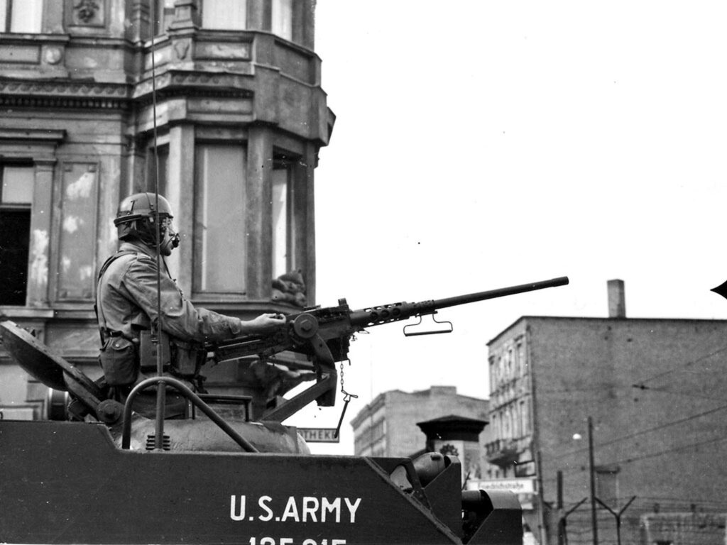 Ein Soldat mit einem Maschinengewehr auf einem Panzer der US Army in der Friedrichstraße.