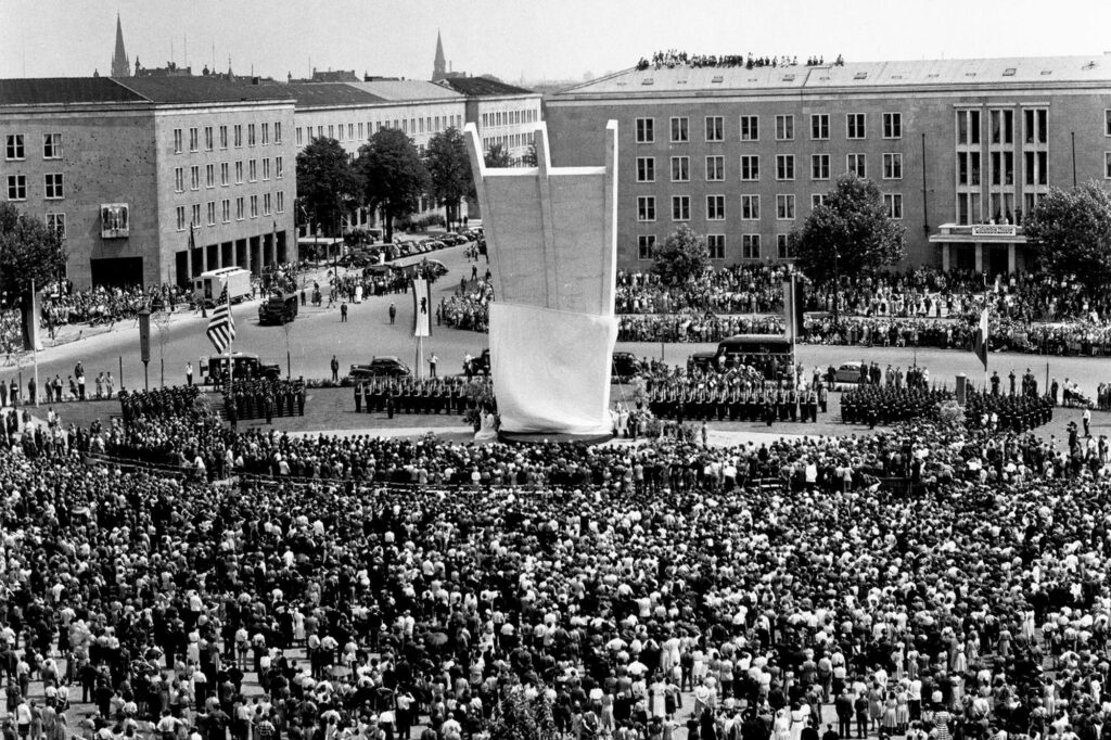 Aerial photograph of a large crowd at the Airlift Memorial, which is just being unveiled.