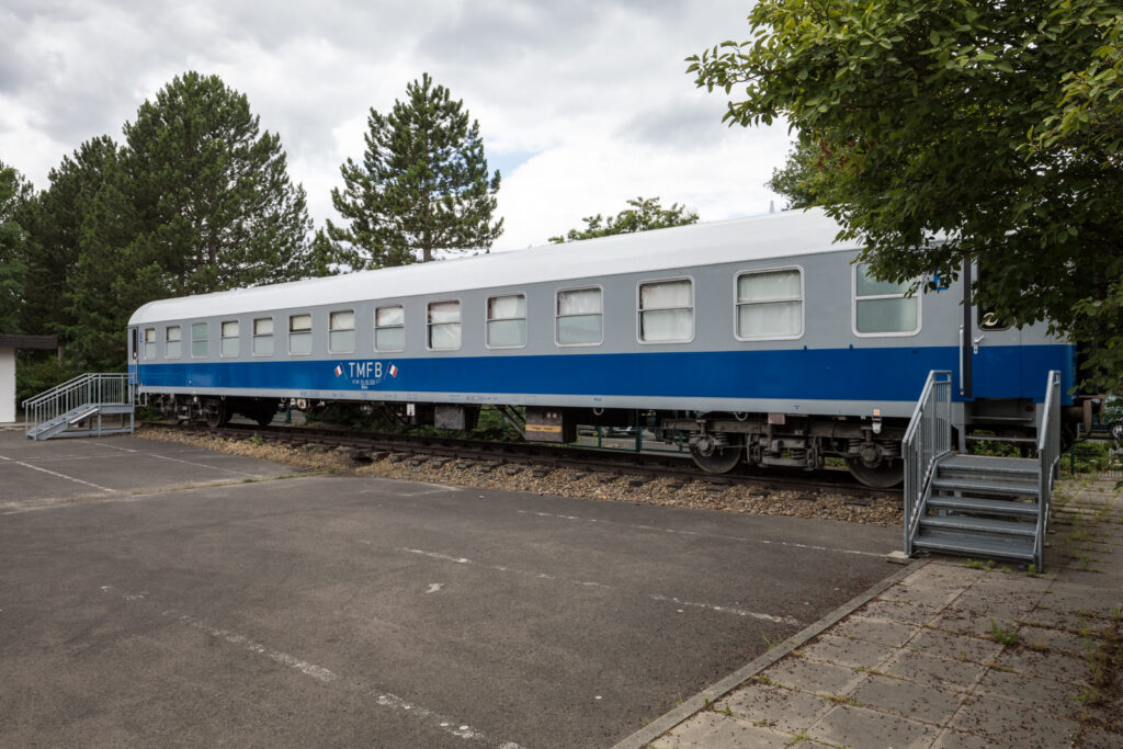 Waggon peint en bleu et gris avec deux tricolores et l'abréviation TMFB. 